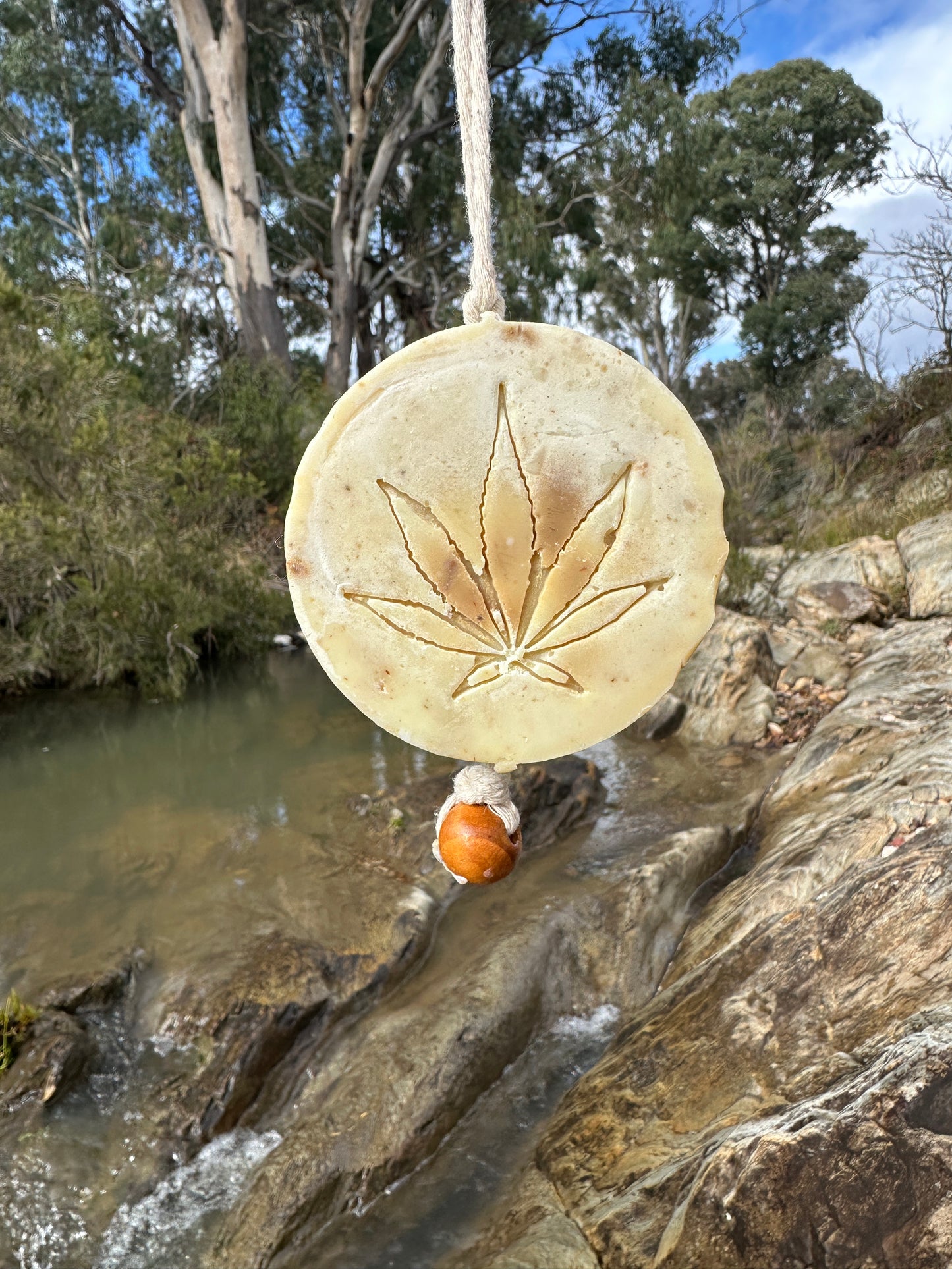 Campbell's Hemp Scrub soap on a rope displayed on a wooden surface, with visible hemp fibers and natural texture, evoking a clean, eco-friendly, and handcrafted skincare vibe.